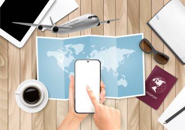 Tatile, geziye, seyahate nasıl hazırlanılır? Seyahat planı. Akıllı telefon kullanarak otel rezervasyonu. Tahta masa, dünya haritası, pasaport, harita, akıllı telefon, uçak..