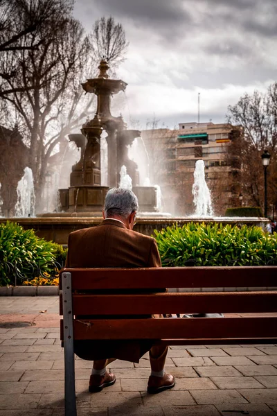 西班牙格拉纳达 2022年2月26日 一名身份不明的老人坐在西班牙安达卢西亚格拉纳达市中心坎皮洛广场的长椅上 — 图库照片