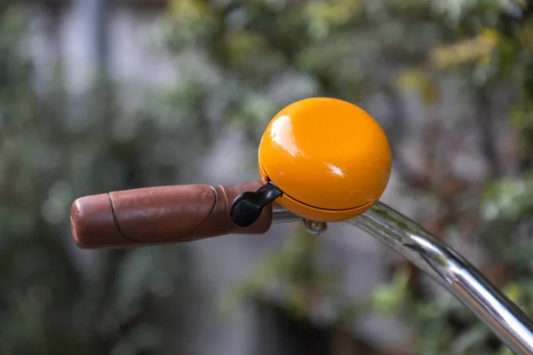 Orange gremlin bell on a bike handlebar, biking accessories