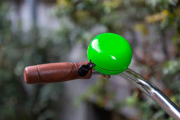 Green gremlin bell on a bike handlebar, biking accessories