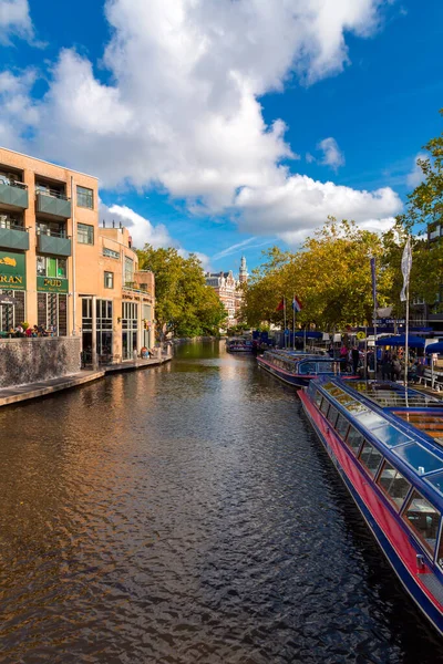 stock image Amsterdam, NL - October 11, 2021: Canals and typical tour boats in Amsterdam, the capital of the Netherlands. Amsterdam is one of the most popular tourist destinations in Europe.