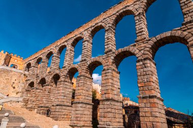 Segovia, Spain - February 18, 2022: The ancient Roman aqueduct of Segovia, one of the best-preserved elevated Roman aqueducts and the foremost symbol of Segovia. clipart