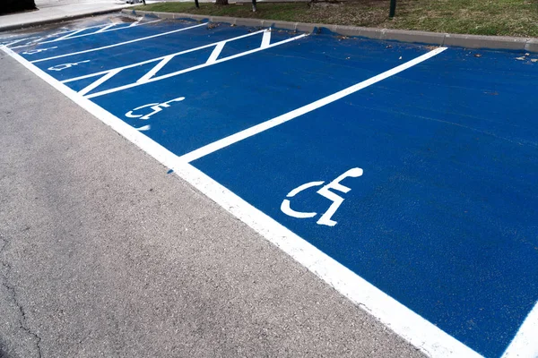 Designated and reserved parking area for disabled drivers, blue and white painted sign on the floor.