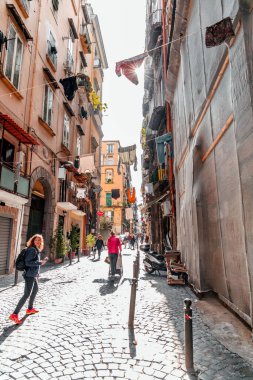 Naples, Italy - April 10, 2022: Spaccanapoli is the straight and narrow main street that traverses the old, historic center of the city of Naples, Italy. clipart