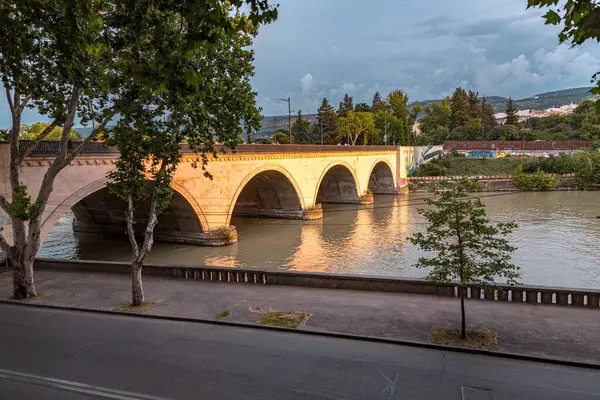 stock image Tbilisi, Georgia - 16 JUNE, 2024: Saarbrucken Bridge on Kura River in Tbilisi, Georgia.