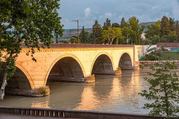 stock image Tbilisi, Georgia - 16 JUNE, 2024: Saarbrucken Bridge on Kura River in Tbilisi, Georgia.