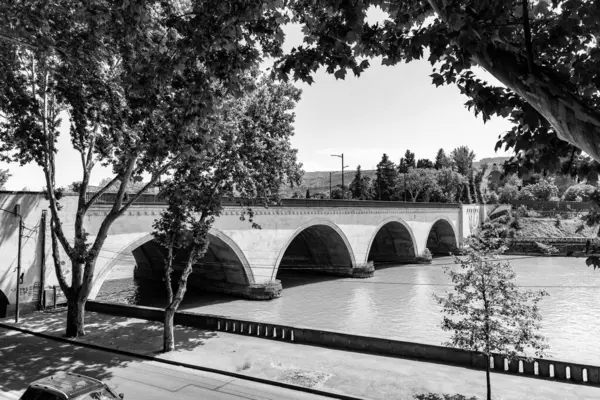 stock image Tbilisi, Georgia - 17 JUNE, 2024: Saarbrucken Bridge on Kura River in Tbilisi, Georgia.