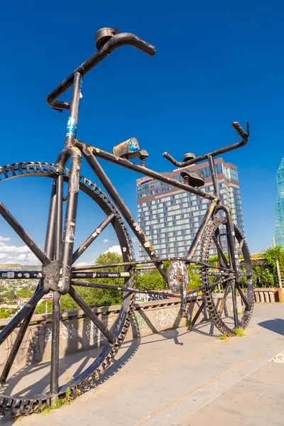 stock image Tbilisi, Georgia - 23 JUNE, 2024: Gigantic bicycle statue with two handle bars and saddles towards opposite directions on the Rose Revolution Square in Tbilisi