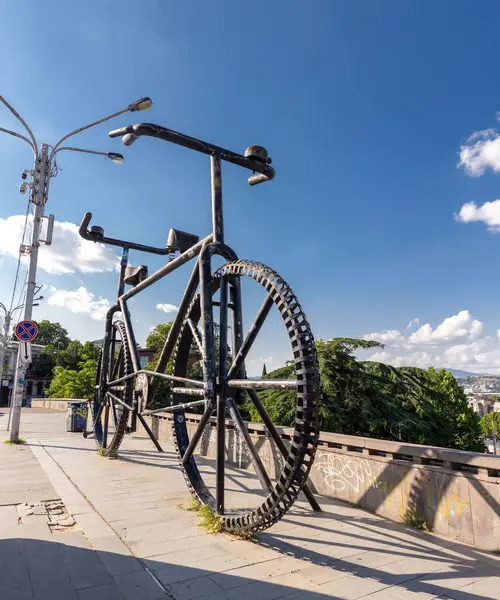 stock image Tbilisi, Georgia - 23 JUNE, 2024: Gigantic bicycle statue with two handle bars and saddles towards opposite directions on the Rose Revolution Square in Tbilisi