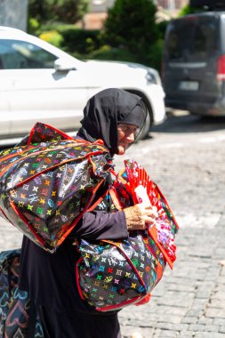 Tbilisi, Georgia - 14 AUG, 2024: Elderly Georgian lady selling items to the visitors in the old town of Tbilisi, Georgia. clipart