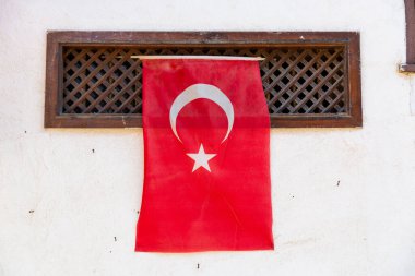 Turkish flag hanging on a white wall in Mudanya, Turkiye. clipart