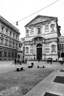 Milan, Italy - 30 March 2022: Piazza San Fedele is situated in the center of Milan, hosting the church of San Fedele, statue of Alessandro Manzoni and Casa Manzoni. clipart