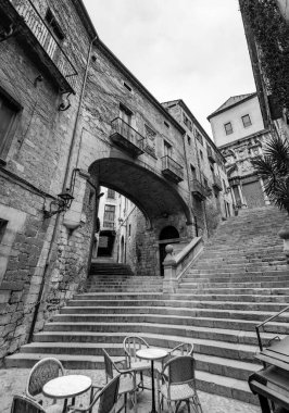 Girona, Catalonia, Spain - FEB 12, 2022: Beautiful steps and archway of the Pujada de Sant Domenec located in the Jewish Quarter of Girona, Catalonia, Spain. clipart