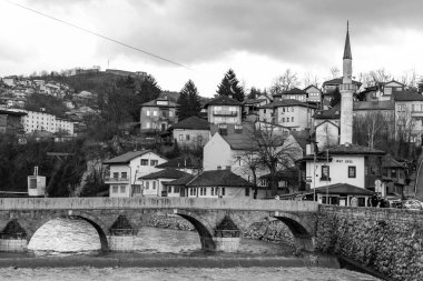 Sarajevo - Bosnia and Herzegovina - 11 FEB 2024: Sehir Kayhasi or Seher Cehaya stone bridge built during the Ottoman period over Miljacka River in Sarajevo. clipart