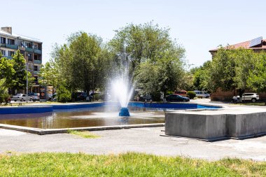 Etchmiadzin, Ermenistan - 23 Haziran 2024: Güneşli yaz gününde Ermenistan 'ın Etchmiadzin kentinde meydanında çeşmeli gölet