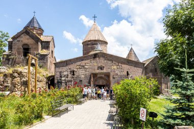 Gosh, Armenia - July 6, 2024: many tourists near entrance to Gavit of St Astvatsatsin church in Goshavank monastery, Armenia on sunny summer day clipart