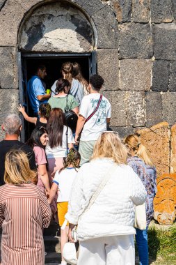 Sevan, Ermenistan - 14 Temmuz 2024: Sevanavank Sevan Manastırı 'ndaki Surp Arakelots Kilisesi' ne girmek için turist kuyruğu Sevan Yarımadası 'nda güneşli bir yaz günü