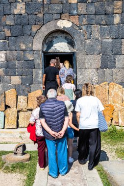 Sevan, Ermenistan - 14 Temmuz 2024: Sevanavank Sevan Manastırı 'ndaki Surp Arakelots Kilisesi' ne güneşli bir yaz günü Sevan Yarımadası 'nda girmek üzere ziyaretçi kuyruğu