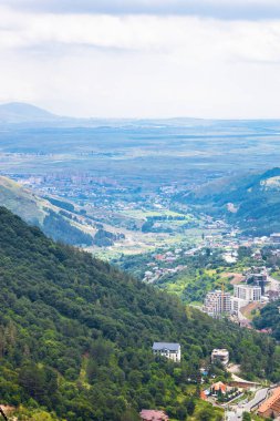 Ermenistan 'ın Tsaghkadzor kasabası ile dağ vadisi manzarasının üzerinde dağlarda bulutlu bir yaz günü