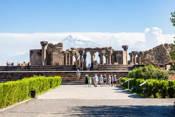 stock image Zvartnots, Armenia - June 23, 2024: tourists near ruins of Zvartnots Cathedral with Mount Ararat on background in Armenia on sunny summer day. Zvartnots ruins are listed in UNESCO World Heritage Sites