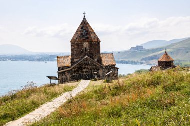 Sevanavank Sevan Manastırı 'ndaki kiliselere giden yol güneşli bir yaz günü Sevan Yarımadası' nın tepesinde.