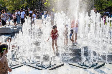 Erivan, Ermenistan - 10 Ağustos 2024: Güneşli yaz gününde Erivan 2800. yıldönümü parkındaki çeşme havuzunda çocuklar