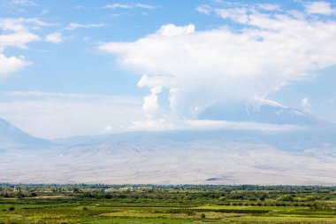 Türkiye 'nin Ermenistan' ın Erarat ilçesine bağlı Ararat Ovası yakınlarındaki tarımsal tarlalara yaz günü Khor Virap manastırı ve Ararat Dağı 