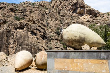 old kvevri wine vessels and rocks in background in Areni village in Vayots Dzor Provinces, Armenia on sunny summer day clipart