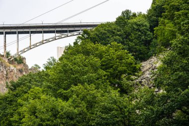 Ermenistan 'ın Vayots Dzor şehrinde yağmurlu bir yaz gününde Jermuk Şelalesi' nin yakınındaki Arpa nehri geçidinde köprü.