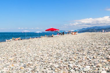 Batumi, Gürcistan - 15 Eylül 2023: Güneşli bir sonbahar gününde Karadeniz 'de şehir çakıl taşı plajının yüzeyi