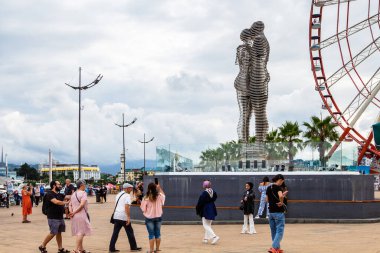 Batumi, Gürcistan - 16 Eylül 2023: Erkek ve Kadın Heykeli (Ali ve Nino) yakınında gezinen insanlar ve sonbahar günü Batum şehrinde arka planda gri bulutlar