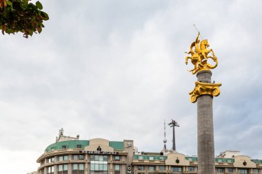 Tiflis, Gürcistan - 22 Eylül 2023: Bulutlu bir sonbahar gününde, Tiflis şehrinin merkezinde Özgürlük Meydanı 'ndaki Özgürlük Anıtı' nda ejderha öldüren Aziz George altın heykeli