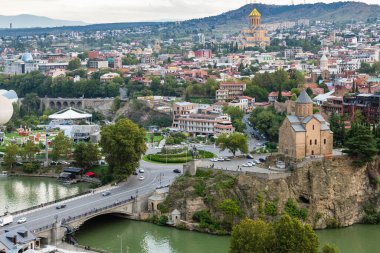 Tbilisi, Georgia - September 23, 2023: above view of Tbilisi city with Mettekhi and Sameba churches from Narikala fortress on cloudy autumn evening clipart