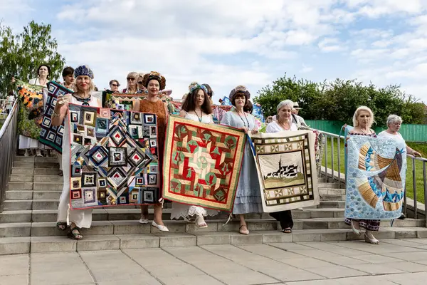 Kolomna, Rusya - 11 Haziran 2022: Eski Kolomna şehrindeki Kolomna Kremlin 'de düzenlenen Uluslararası Patchwork Festivali sırasında el yapımı yama işi yorganlarla geçit töreni