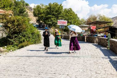 Garni, Ermenistan - 30 Eylül 2023: Turistler, güneşli bir sonbahar gününde Ermenistan 'ın Garni vadisindeki taşların konseri için senfoniye giderler.