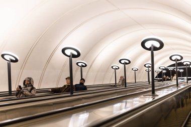 Moskova, Rusya - 22 Şubat 2023: Yolcular Moskova 'daki Michurinsky Prospekt metro istasyonunun uzun yürüyen merdiveniyle metroya iniyor.