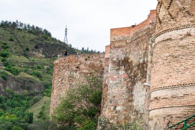 Tiflis, Gürcistan - 23 Eylül 2023: Bulutlu bir sonbahar gününde Tiflis 'teki Sololaki tepesindeki antik Narikala kalesinin dış duvarları