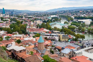 Tiflis, Gürcistan - 23 Eylül 2023: Bulutlu bir sonbahar gününde Narikala kalesinden Aziz George Kilisesi ile birlikte Tiflis şehrinin yukarısı