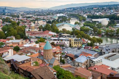 Tiflis, Gürcistan - 23 Eylül 2023: Bulutlu bir sonbahar akşamında Narikala kalesinden Kura nehri ile eski Tiflis şehri manzarası üzerinde