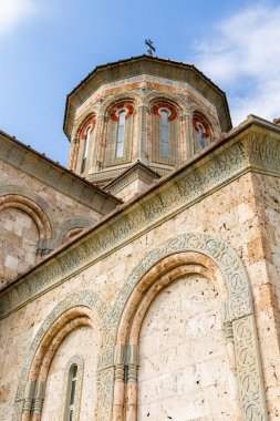 Bodbe, Georgia - September 24, 2023: bottom view of wall and tower of new St Nino church in Bodbe Monastery in Kakheti region of Georgia on sunny autumn day clipart