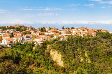Signagi, Gürcistan - 24 Eylül 2023: Güneşli sonbahar gününde Gürcistan 'ın Kakheti bölgesinde dağın tepesinde güneşle aydınlanan Sighnaghi kasabası