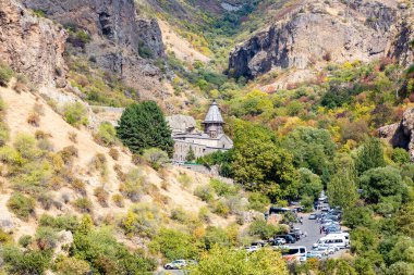 Goght, Ermenistan - 30 Eylül 2023: güneşli bir sonbahar gününde Yukarı Azat Vadisi 'ndeki Geghard Manastırı' na park etmiş araçlarla yol. Geghard UNESCO Dünya Mirası Listesi