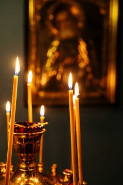 Cenaze mumları karanlık kilisedeki ikonun önünde sunakta yanar.