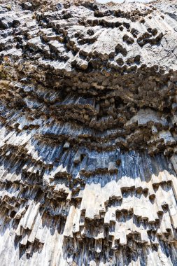 symphony of the stones - bottom view of natural basalt columns in Garni gorge in Armenia on sunny autumn day clipart