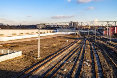 Güneşli bir sonbahar gününde gün batımı güneşinin aydınlattığı demiryolunun kenarındaki boş demiryolu raylarının üzerinde.