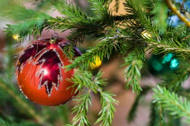 Doğal noel ağacında yaprak desenli kırmızı cam top.