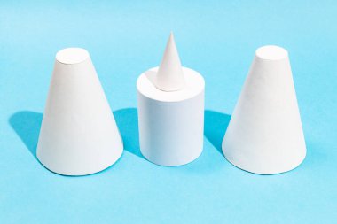 Turkuaz mavi zemin üzerinde el yapımı kağıt koniler ve silindirler