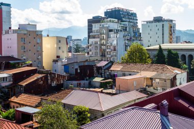 Gürcistan 'a seyahat - güneşli bir sabahta Batumi şehrinin yerleşim bölgesindeki bir katlı ve çok katlı evlerin manzarası