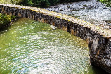 Gürcistan 'a yolculuk - Adjara' daki Machakhela Nehri üzerindeki Tskhemlara taş köprüsü güneşli sonbahar gününde