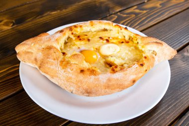 travel to Georgia - khachapuri in Adjarian style (boat shaped with soft cheese, egg, butter) in local cafe in Batumi city clipart